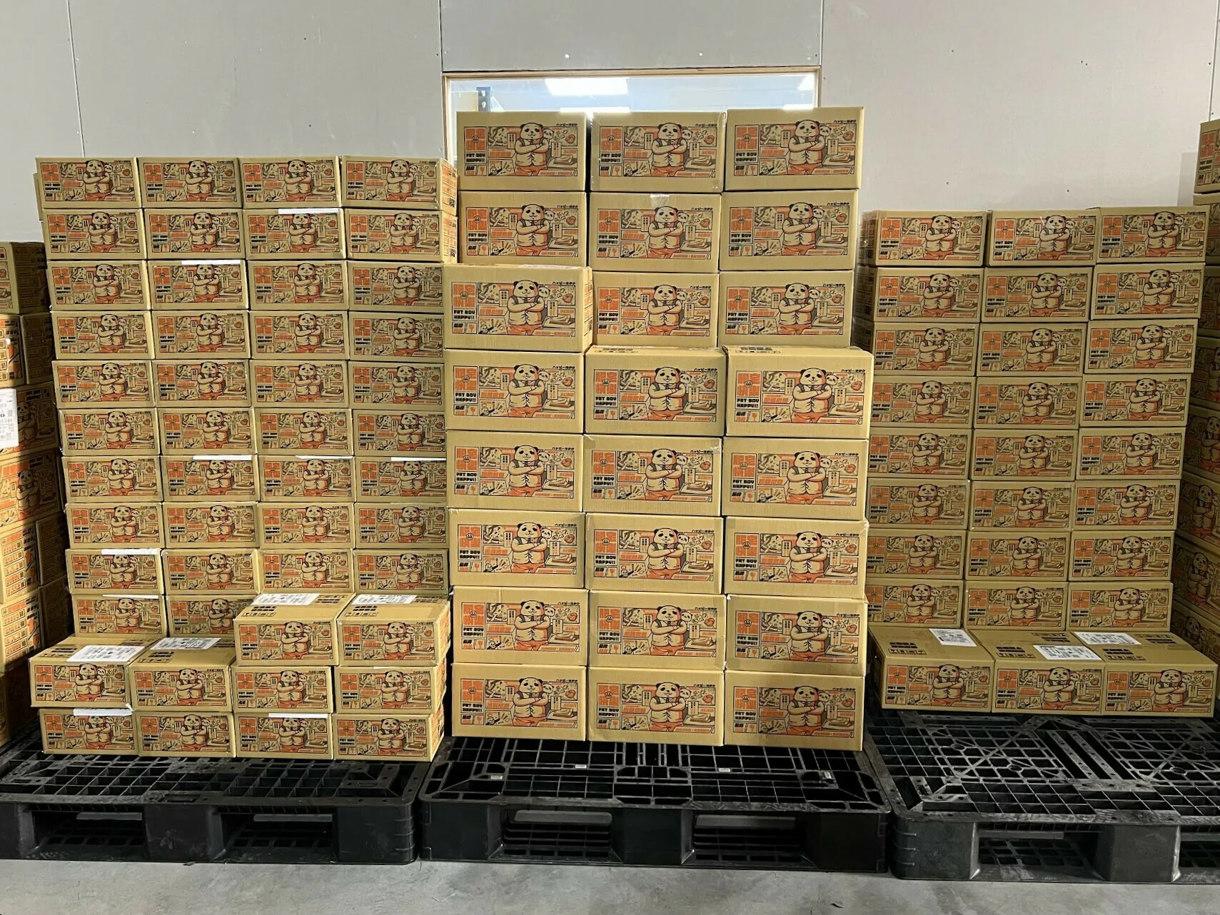 肥宅叔叔自家品牌的商品紙箱，堆在倉庫的棧板上